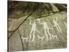 Petroglyph with three men brandishing axes, accompanied by dogs-Werner Forman-Stretched Canvas