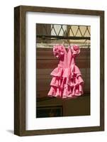 Pink flamenco dress for little girl hangs in Centro old district of Sevilla Spain-null-Framed Photographic Print