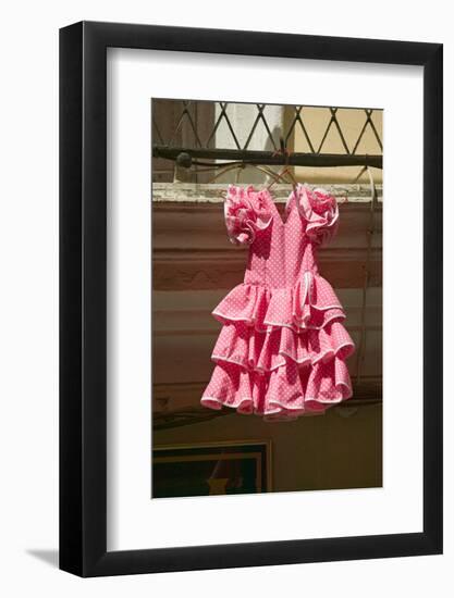 Pink flamenco dress for little girl hangs in Centro old district of Sevilla Spain-null-Framed Photographic Print