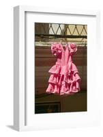 Pink flamenco dress for little girl hangs in Centro old district of Sevilla Spain-null-Framed Photographic Print