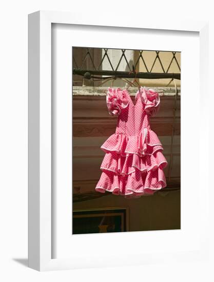 Pink flamenco dress for little girl hangs in Centro old district of Sevilla Spain-null-Framed Photographic Print