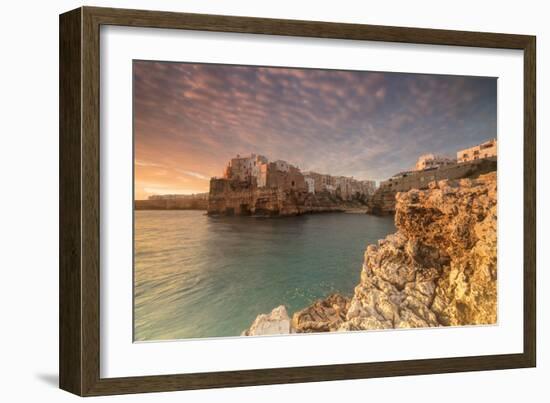 Pink sunrise on the turquoise sea framed by old town perched on the rocks, Polignano a Mare, Provin-Roberto Moiola-Framed Photographic Print