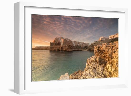 Pink sunrise on the turquoise sea framed by old town perched on the rocks, Polignano a Mare, Provin-Roberto Moiola-Framed Photographic Print