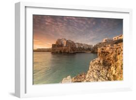 Pink sunrise on the turquoise sea framed by old town perched on the rocks, Polignano a Mare, Provin-Roberto Moiola-Framed Photographic Print