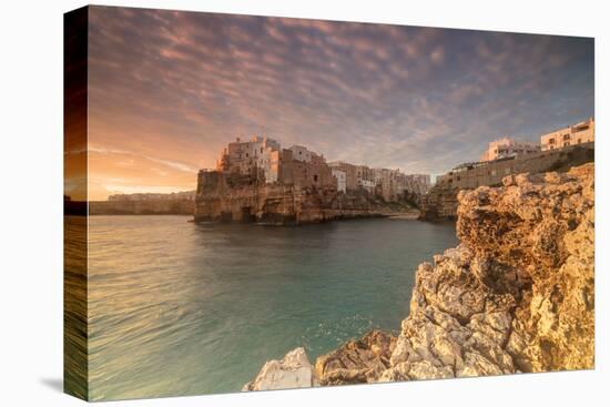 Pink sunrise on the turquoise sea framed by old town perched on the rocks, Polignano a Mare, Provin-Roberto Moiola-Stretched Canvas