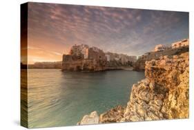 Pink sunrise on the turquoise sea framed by old town perched on the rocks, Polignano a Mare, Provin-Roberto Moiola-Stretched Canvas