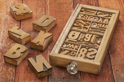 Letterpress Wood Type Blocks in a Typesetter Drawer against Rustic Red Barn Wood