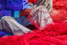 A Closeup to Fisherman's Hands Sewing Red Fishing Sitting on the Ground and Surrounded by Big Red N-Pixinoo-Photographic Print