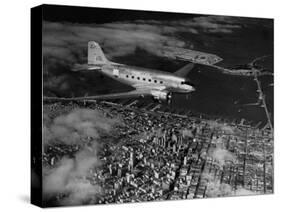 Plane Flying over a City from a Story Concerning United Airlines-Carl Mydans-Stretched Canvas