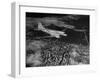 Plane Flying over a City from a Story Concerning United Airlines-Carl Mydans-Framed Photographic Print