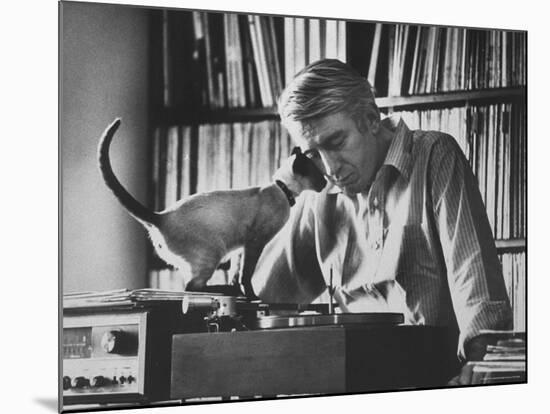 Poet Rod McKuen Playing Record on Stereo Set While Pet Siamese Cat Nuzzles His Face Affectionately-Ralph Crane-Mounted Premium Photographic Print