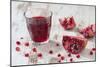 Pomegranate Pieces and a Glass of Pomegranate Juice on White Wooden Table-Jana Ihle-Mounted Photographic Print
