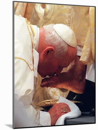 Pope John Paul II Kisses the Foot of a Clergyman-null-Mounted Photographic Print