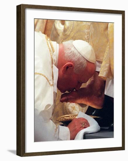 Pope John Paul II Kisses the Foot of a Clergyman-null-Framed Photographic Print