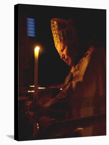 Pope John Paul II Prays Before a Candle at the Beginning of an Holy Easter Vigil Mass-null-Stretched Canvas