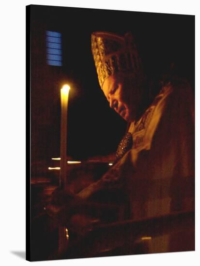 Pope John Paul II Prays Before a Candle at the Beginning of an Holy Easter Vigil Mass-null-Stretched Canvas