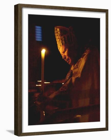 Pope John Paul II Prays Before a Candle at the Beginning of an Holy Easter Vigil Mass-null-Framed Premium Photographic Print