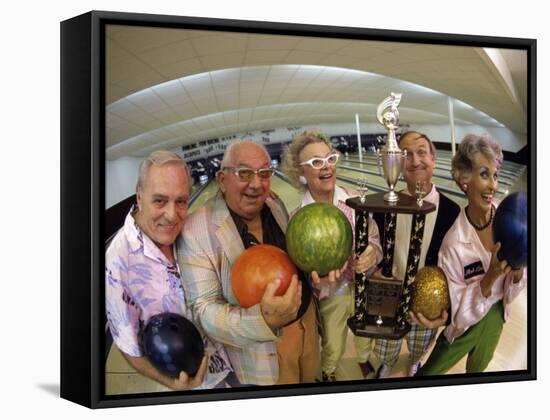 Portrait of a Group of Senior People Holding a Bowling Trophy at a Bowling Alley-null-Framed Stretched Canvas