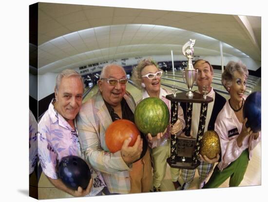 Portrait of a Group of Senior People Holding a Bowling Trophy at a Bowling Alley-null-Stretched Canvas