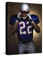 Portrait of an American Football Player Removing His Helmet-null-Stretched Canvas