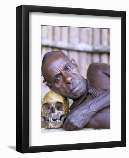 Portrait of an Asmat Tribesman Leaning on a Human Skull, Irian Jaya, Indonesia-Claire Leimbach-Framed Photographic Print