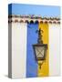 Portugal, Obidos. Wrought iron lantern hanging from a colorful stripped wall in the walled town.-Julie Eggers-Stretched Canvas