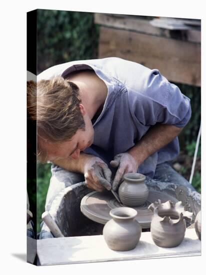 Potter at Work on Wheel at Rustic Fayre, Devon, England, United Kingdom-Ian Griffiths-Stretched Canvas