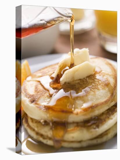 Pouring Maple Syrup over Pancakes with Dab of Butter-null-Stretched Canvas