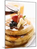 Pouring Maple Syrup over Waffles with Butter and Berries-null-Mounted Photographic Print