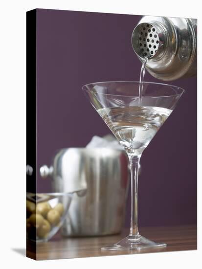 Pouring Martini Out of Cocktail Shaker into Glass-null-Stretched Canvas