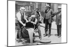 Pouring Out Illegal Alcohol into a Sewer-null-Mounted Art Print