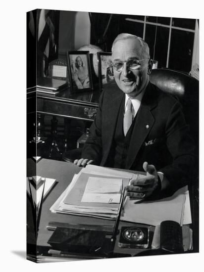 Pres. Harry S. Truman Seated at His Desk in the White House, Family Photographs on Table Behind Him-Gjon Mili-Stretched Canvas