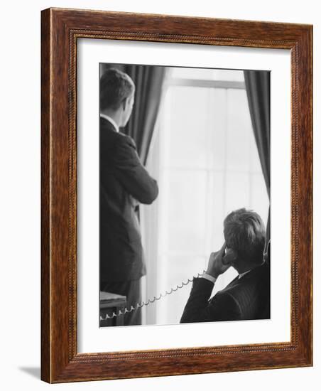 Pres. John F. Kennedy on Telephone While Brother, Attorney General Robert F. Kennedy Stands Nearby-Art Rickerby-Framed Photographic Print