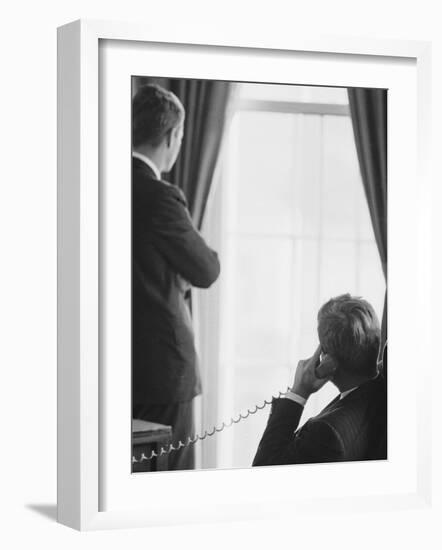 Pres. John F. Kennedy on Telephone While Brother, Attorney General Robert F. Kennedy Stands Nearby-Art Rickerby-Framed Photographic Print