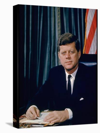 Pres. John F. Kennedy Sitting at His Desk, with Flag in Bkgrd-Alfred Eisenstaedt-Stretched Canvas