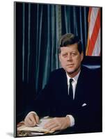 Pres. John F. Kennedy Sitting at His Desk, with Flag in Bkgrd-Alfred Eisenstaedt-Mounted Premium Photographic Print