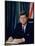 Pres. John F. Kennedy Sitting at His Desk, with Flag in Bkgrd-Alfred Eisenstaedt-Mounted Premium Photographic Print