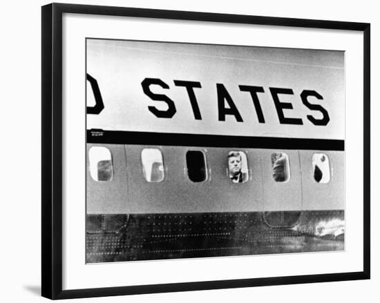 President John Kennedy Peers Out from Window of Air Force One-null-Framed Photo