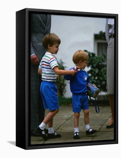 Prince Harry wearing a blue sweatshirt shorts and thomas the tank engine bag with Prince William on-null-Framed Stretched Canvas