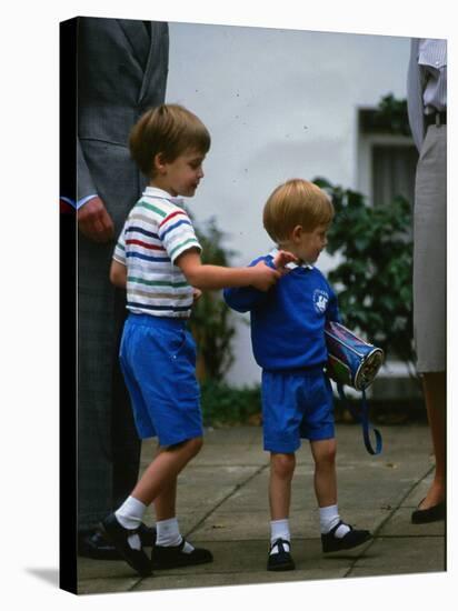 Prince Harry wearing a blue sweatshirt shorts and thomas the tank engine bag with Prince William on-null-Stretched Canvas