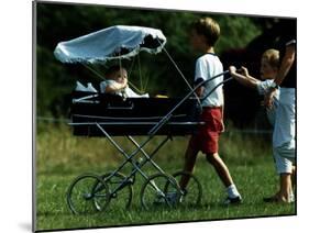 Princess Beatrice is being pushed in pram by Prince william and Harry-null-Mounted Photographic Print