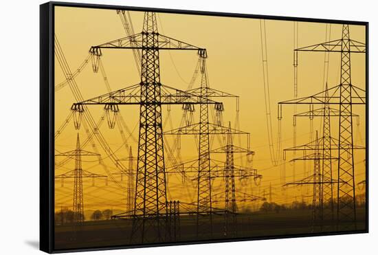 Pylons and power lines in morning light, Germany, Europe-Hans-Peter Merten-Framed Stretched Canvas