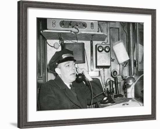 Railroad Conductor Uses an on Board Telephone to Communicate with Other Parts of the Train-null-Framed Photo