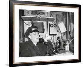 Railroad Conductor Uses an on Board Telephone to Communicate with Other Parts of the Train-null-Framed Photo