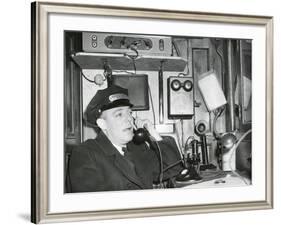 Railroad Conductor Uses an on Board Telephone to Communicate with Other Parts of the Train-null-Framed Photo