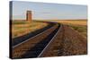 Railroad Tracks Lead to Old Wooden Granary in Collins, Montana, Usa-Chuck Haney-Stretched Canvas