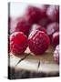 Raspberries on a Wooden Surface-Martina Schindler-Stretched Canvas