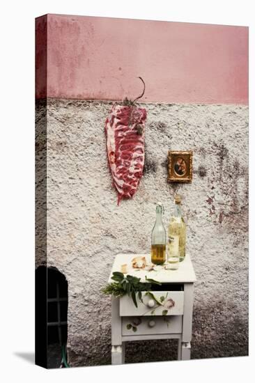 Raw Pork Ribs Hanging on the Wall of a House, Next to a A Gold-Framed Picture-Maria Brinkop-Stretched Canvas