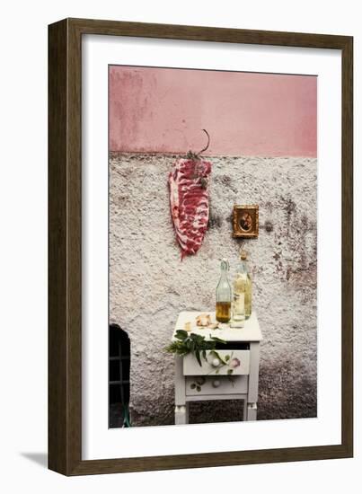 Raw Pork Ribs Hanging on the Wall of a House, Next to a A Gold-Framed Picture-Maria Brinkop-Framed Photographic Print
