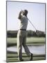 Rear View of a Senior Man Swinging a Golf Club-null-Mounted Photographic Print